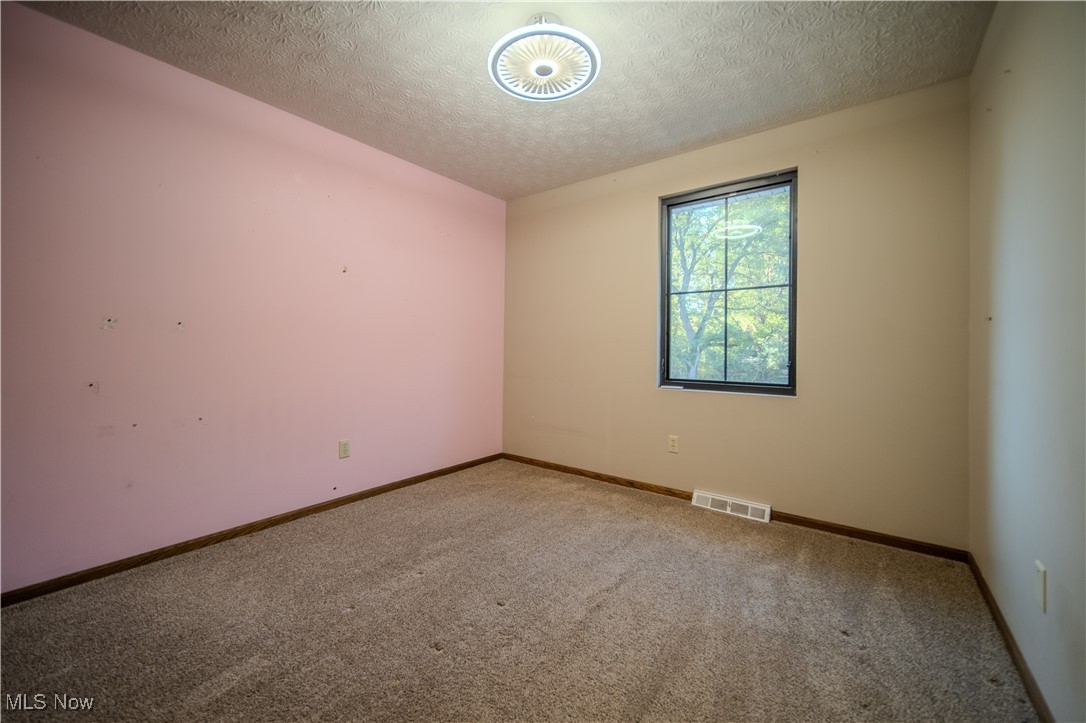 3459 Laubert Road Atwater, OH 44201 - Photo 21 of 39 Carpeted empty room with a textured ceiling and baseboards