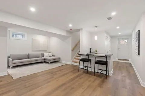 a view of a room with furniture and wooden floor