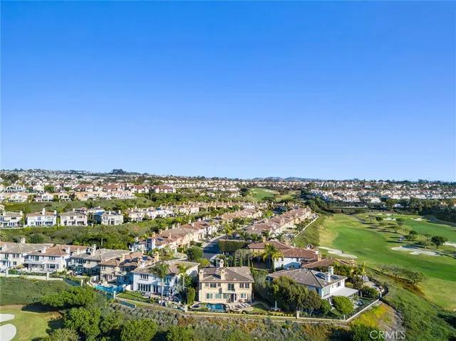 an aerial view of residential houses with outdoor space and ocean view