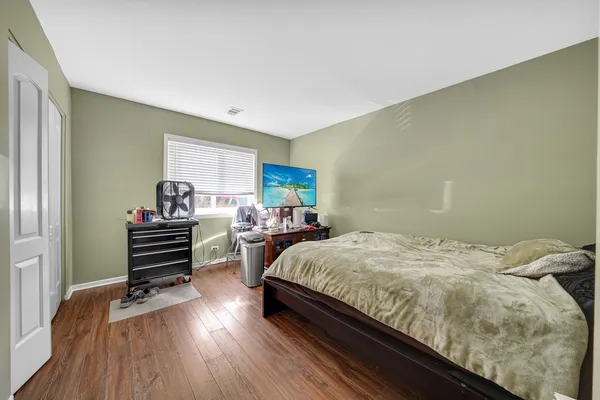 a bedroom with a bed and wooden floor