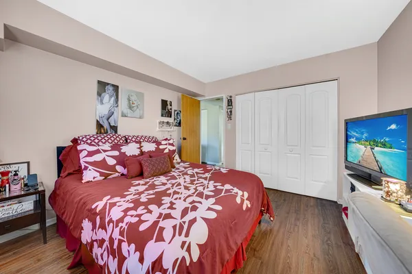 a bedroom with a large bed and a flat tv screen on a dresser