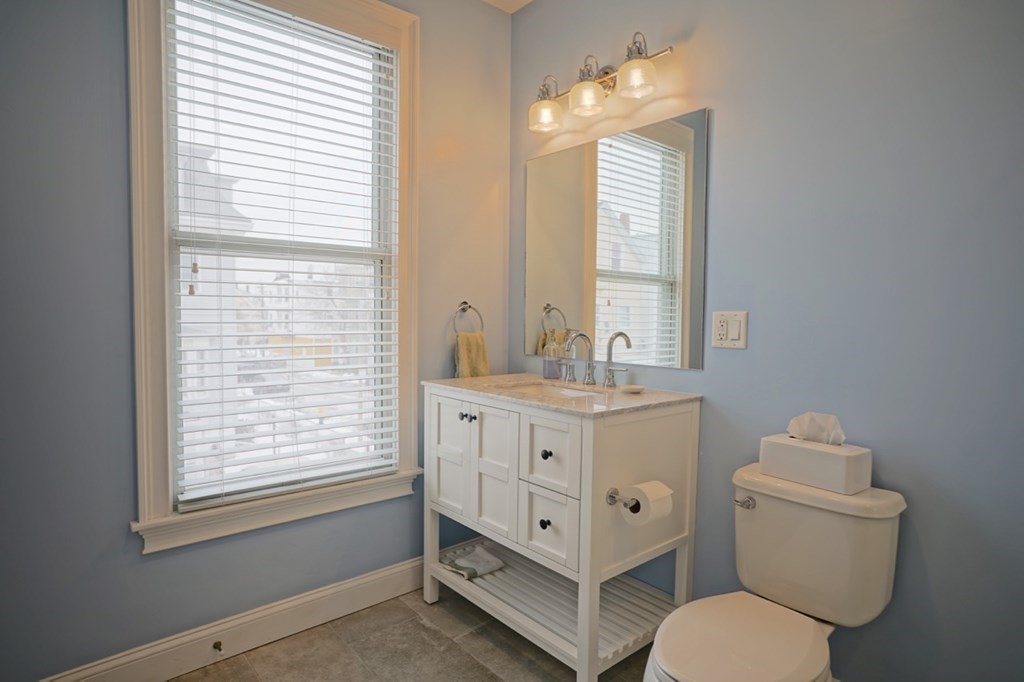 249 Lexington Street, Unit 2 Boston, MA 02128 - Photo 11 of 28 a bathroom with a granite countertop toilet a sink and a window