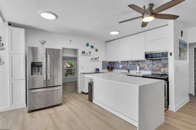 a kitchen with stainless steel appliances a refrigerator a stove sink and a refrigerator