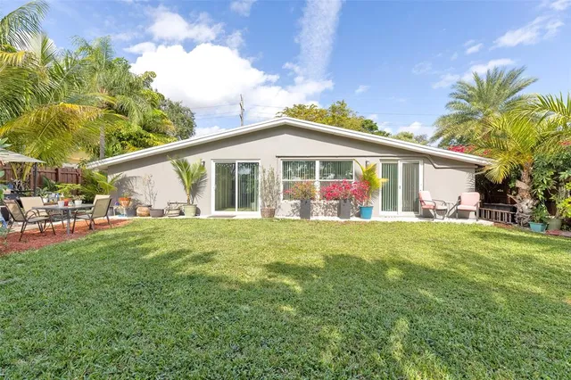 a view of a house with a big yard and potted plants