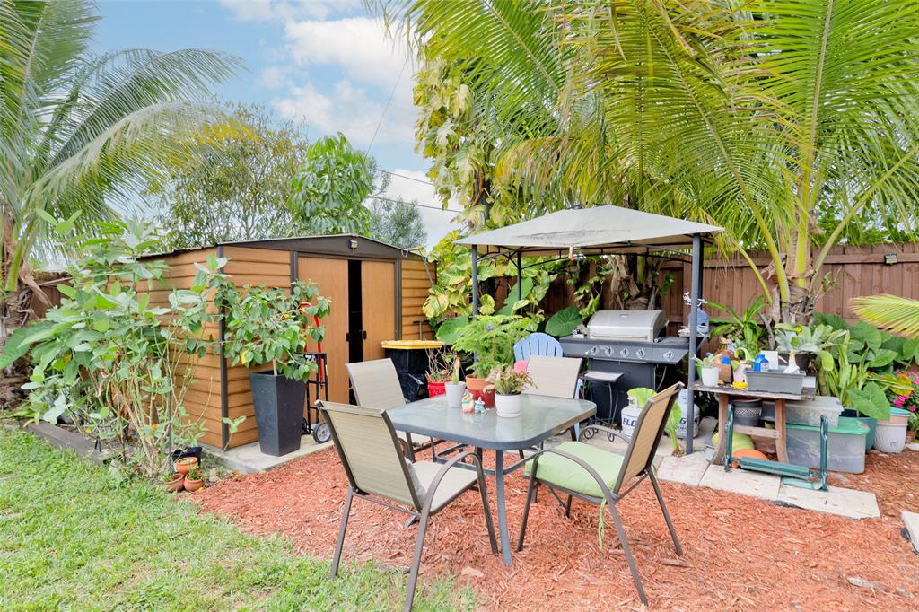 3194 Taft Street Hollywood, FL 33021 - Photo 48 of 48 a view of a table and chairs in patio under an umbrella