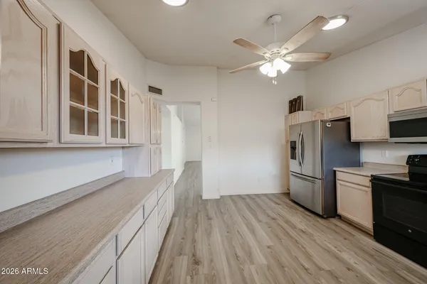 a view of a kitchen with a sink a ceiling fan and stainless steel appliances