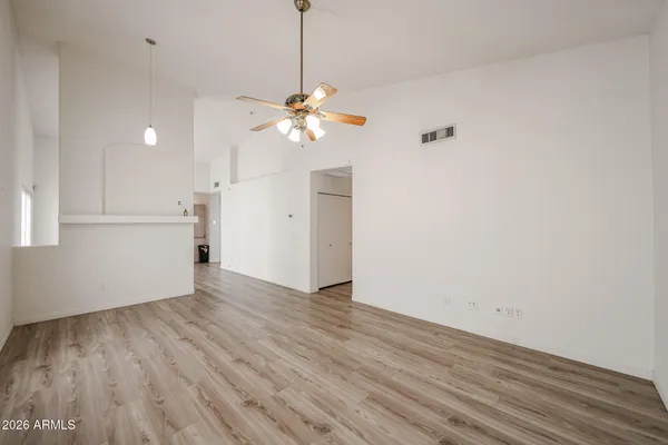 a view of a room with wooden floor and a ceiling fan