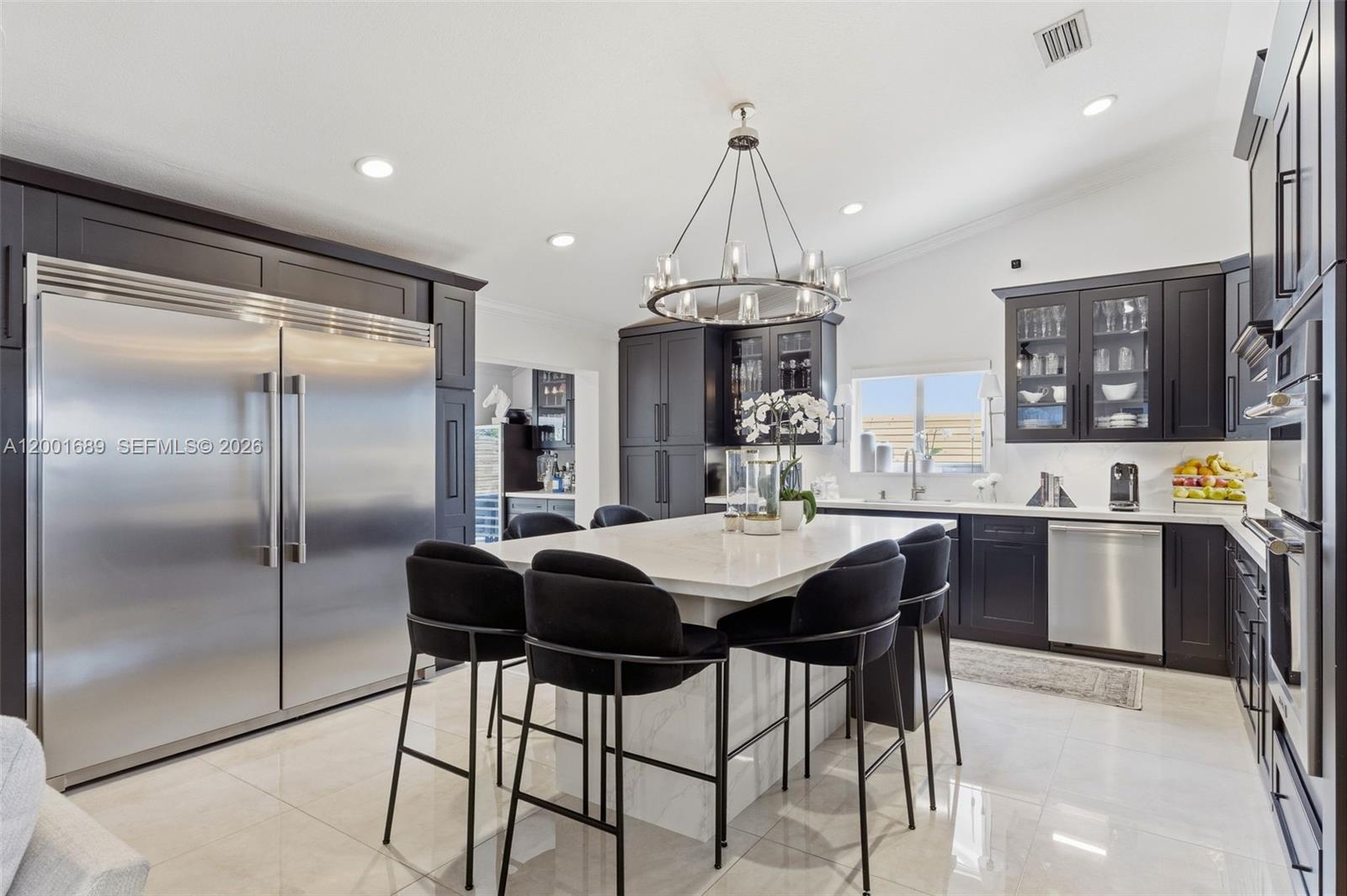 14491 Southwest 161 Street Miami, FL 33177 - Photo 16 of 55 a kitchen with stainless steel appliances a dining table chairs and white cabinets