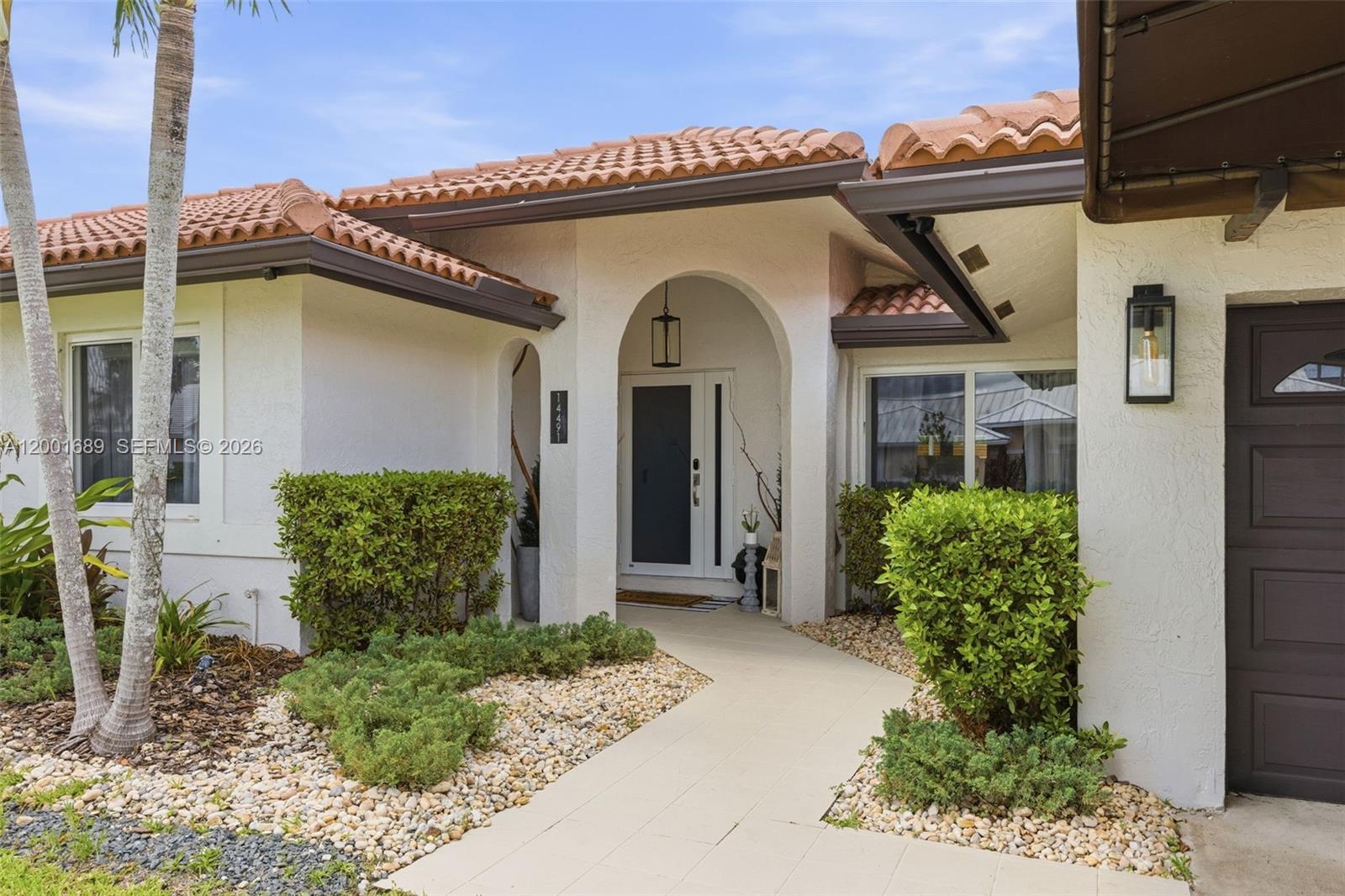 14491 Southwest 161 Street Miami, FL 33177 - Photo 4 of 55 a front view of a house with garden