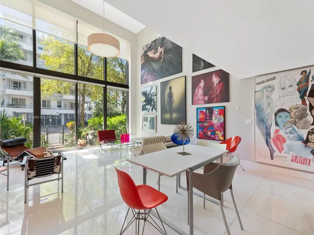 a view of a dining room with furniture one side kitchen view and wooden floor