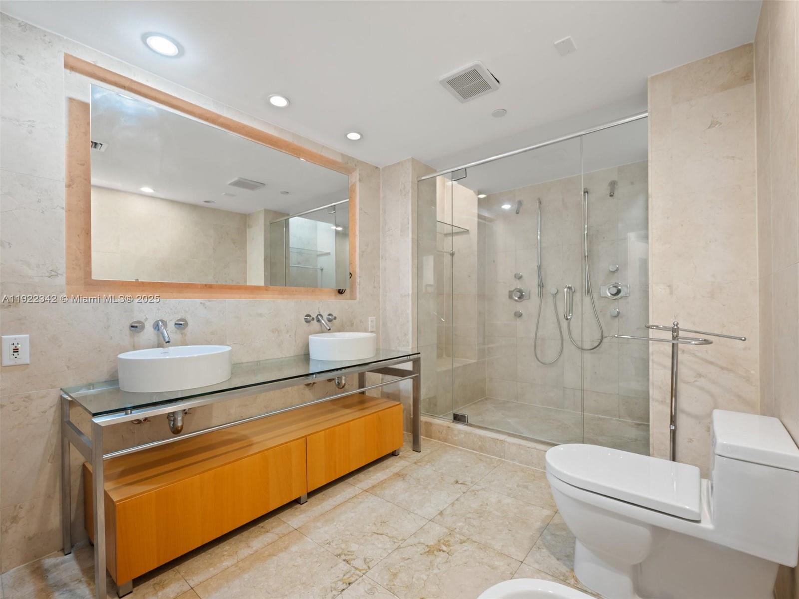 6000 Collins Avenue, Unit 132 Miami Beach, FL 33140 - Photo 7 of 14 a spacious bathroom with a sink mirror toilet and shower