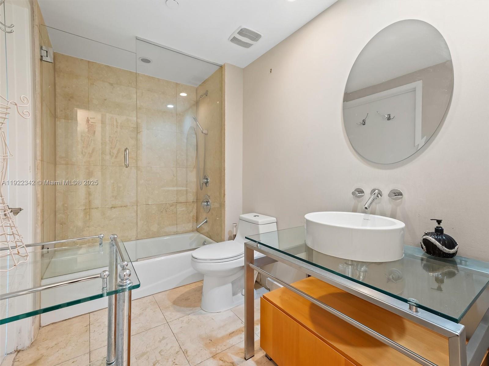 6000 Collins Avenue, Unit 132 Miami Beach, FL 33140 - Photo 9 of 14 a bathroom with a sink a toilet and a mirror