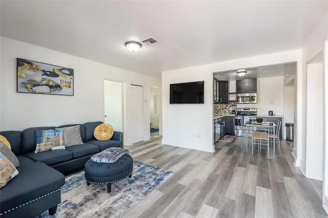 a living room with furniture and a wooden floor