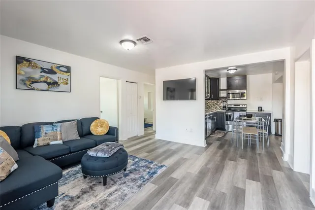 a living room with furniture and a wooden floor