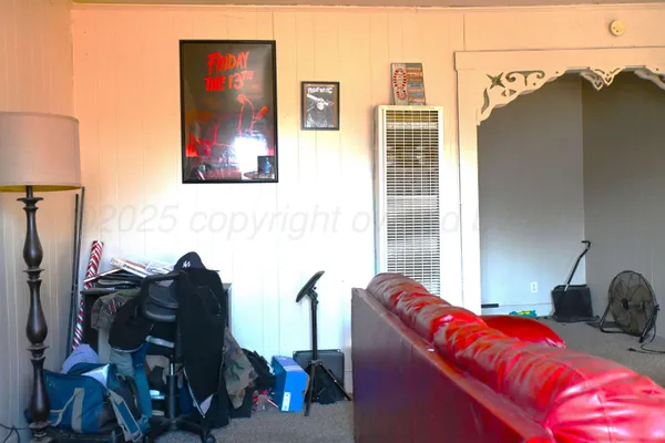 a living room with furniture a flat screen tv and a window