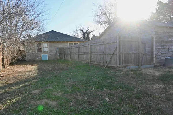 a view of a yard in front of a house with large trees