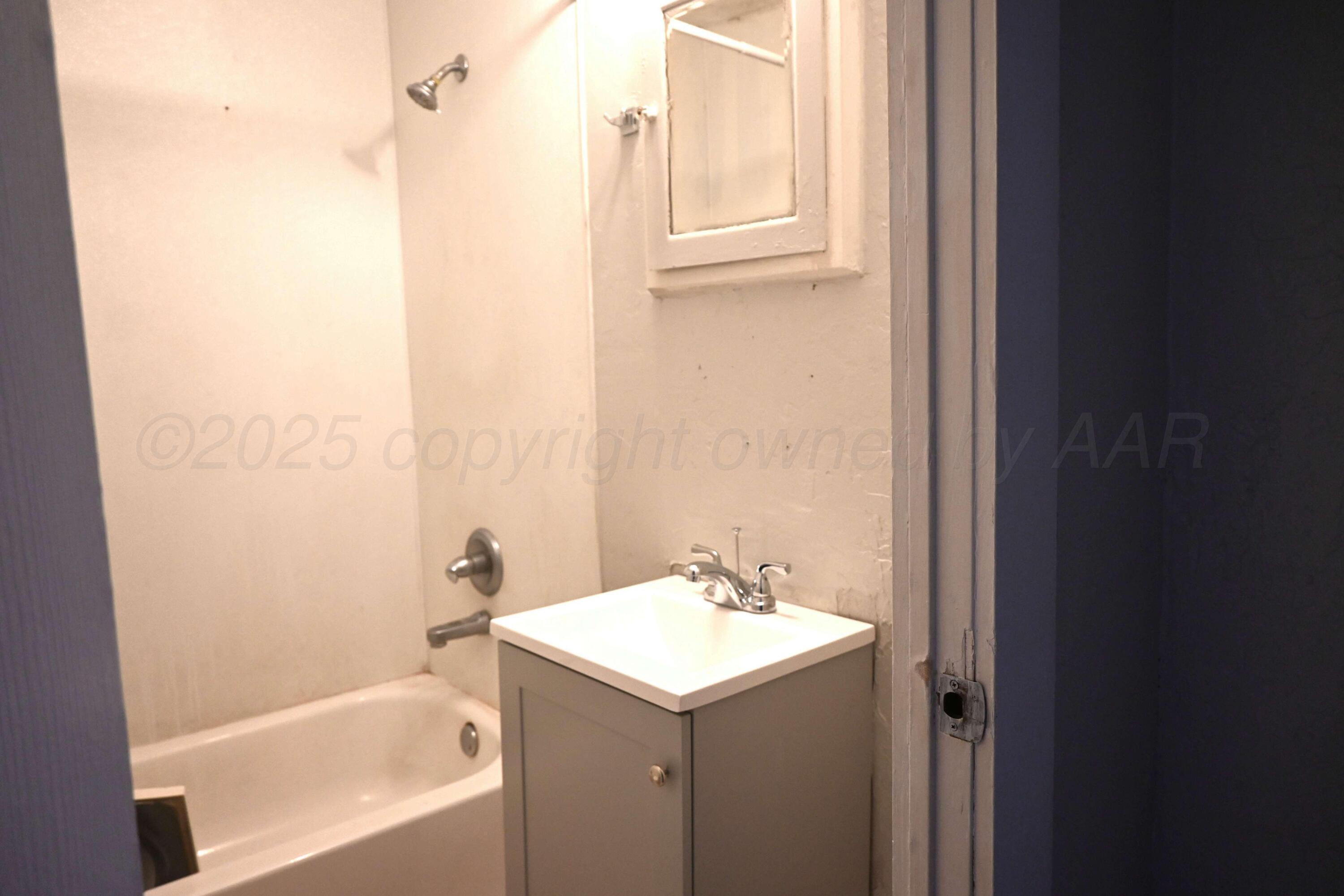3702 South Polk Street Amarillo, TX 79110 - Photo 3 of 19 a bathroom with a sink and a bathtub