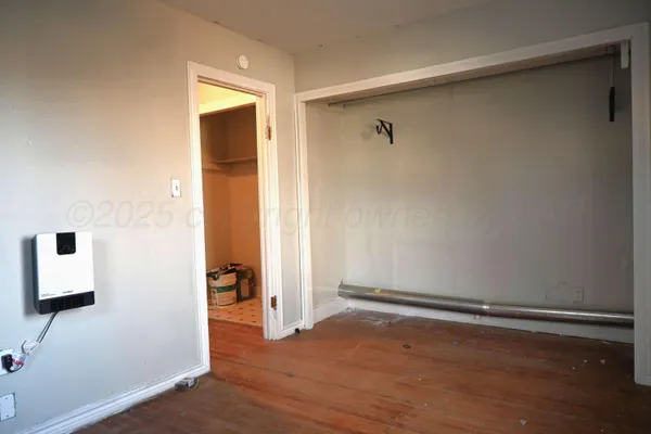 an empty room with wooden floor and closet