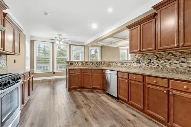 a kitchen with stainless steel appliances granite countertop wooden floors and sink