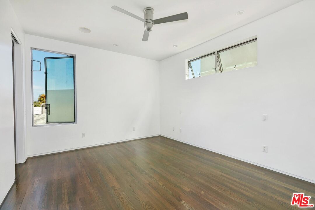705 Sunset Avenue, Unit 1/2 Venice, CA 90291 - Photo 9 of 16 a view of an empty room with wooden floor and a ceiling fan