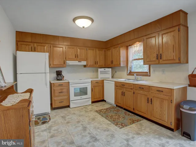 a kitchen with sink refrigerator and cabinets