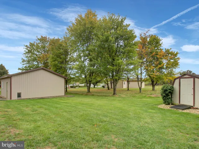 a view of a house with a big yard and large trees