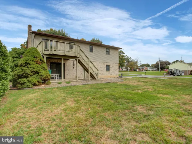 a view of a house with a yard and potted plants