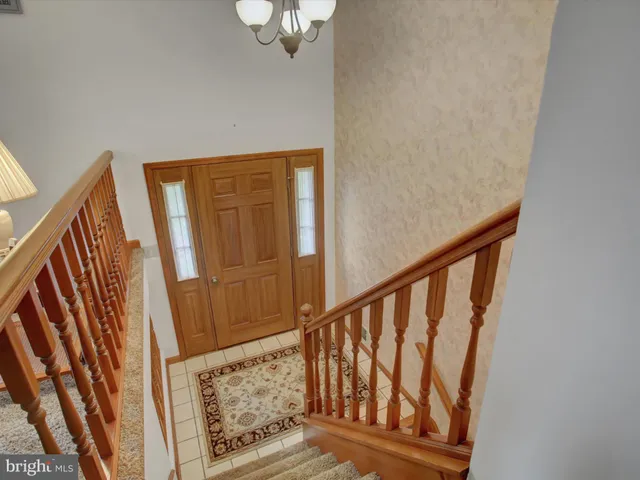 a view of staircase with railing and white walls