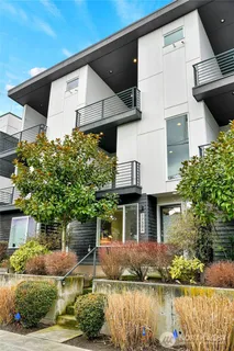 a front view of a house with a yard and potted plants