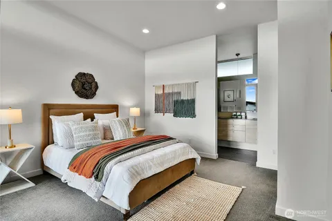 a spacious bedroom with a bed and a lamp