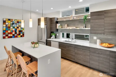 a kitchen with stainless steel appliances granite countertop a kitchen island hardwood floor sink stove and microwave