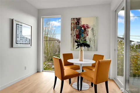 a kitchen with stainless steel appliances granite countertop a stove top oven a refrigerator a sink and chairs