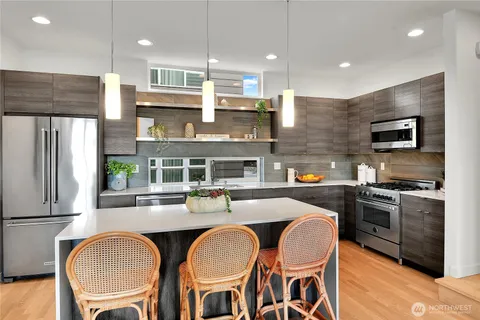 a kitchen with stainless steel appliances granite countertop a sink and a refrigerator