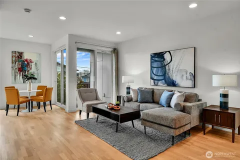 a living room with furniture a rug and kitchen view