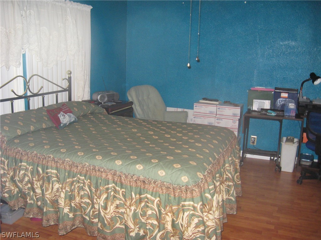 1260 Old Bridge Road North Fort Myers, FL 33917 - Photo 7 of 29 a bedroom with a bed and wooden floor