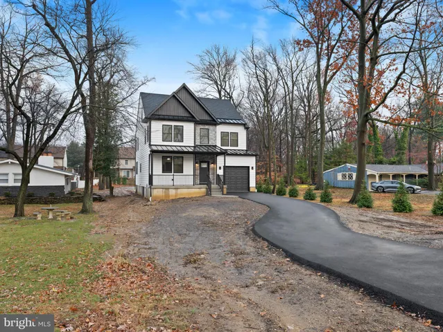 a front view of a house with a yard covered with snow