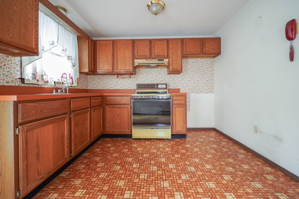 1069 Cherokee Street New Bedford, MA 02745 - Photo 11 of 21 a kitchen with stainless steel appliances granite countertop a stove a sink and a refrigerator