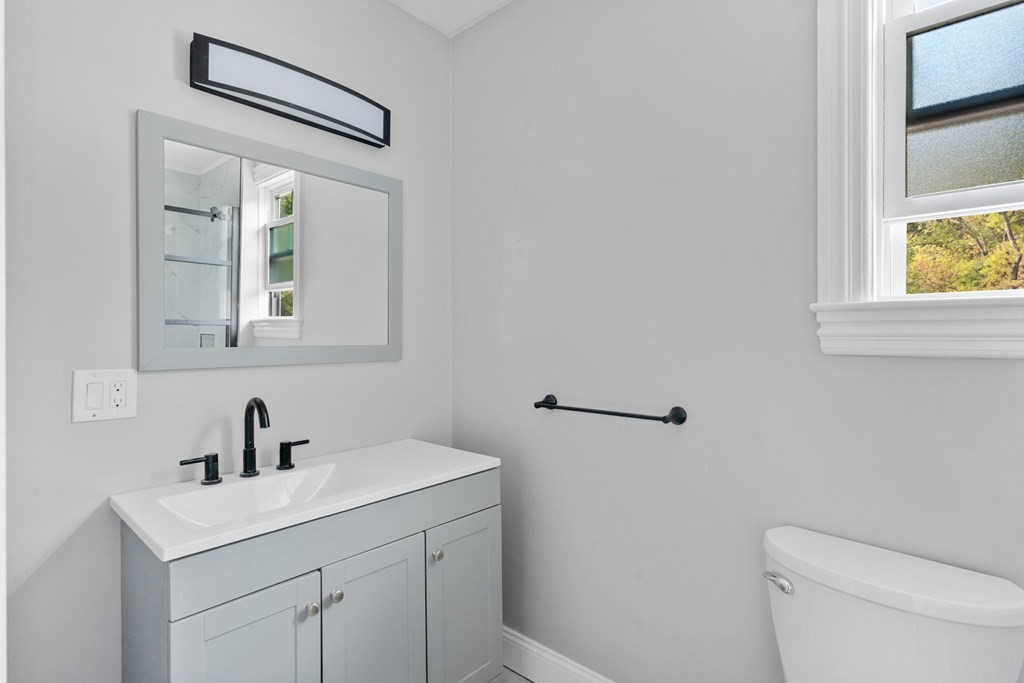 187 Indian Lane Canton, MA 02021 - Photo 11 of 26 a bathroom with a toilet a sink a vanity and mirror