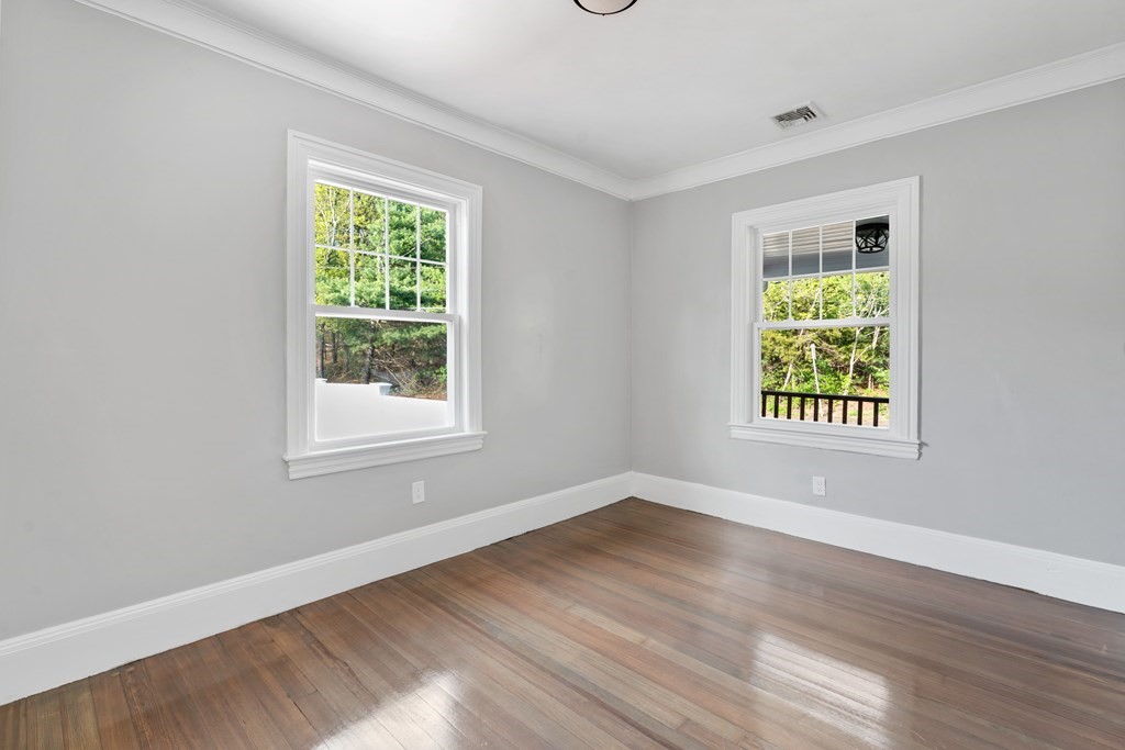 187 Indian Lane Canton, MA 02021 - Photo 13 of 26 a view of an empty room with wooden floor and a window