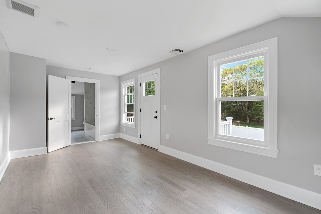187 Indian Lane Canton, MA 02021 - Photo 21 of 26 a view of an empty room with wooden floor and a window