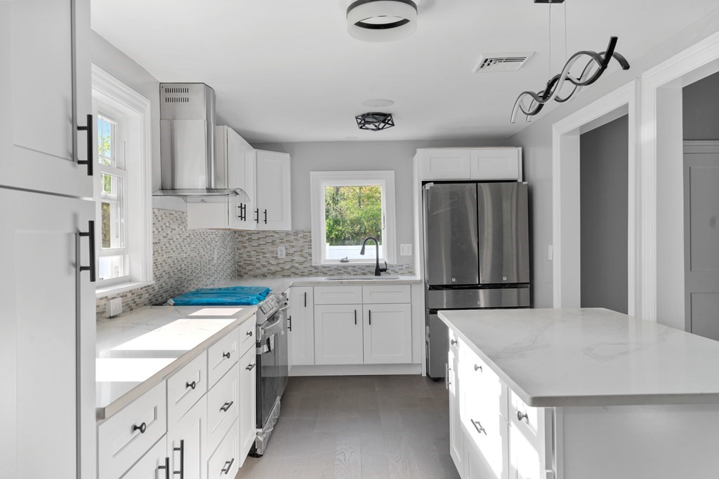 187 Indian Lane Canton, MA 02021 - Photo 7 of 26 a kitchen with a sink a stove a refrigerator and white cabinets