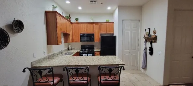 a kitchen with a table chairs refrigerator and microwave