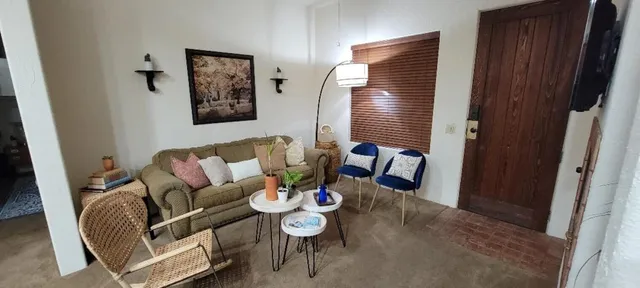 a living room with furniture a flat screen tv and a window
