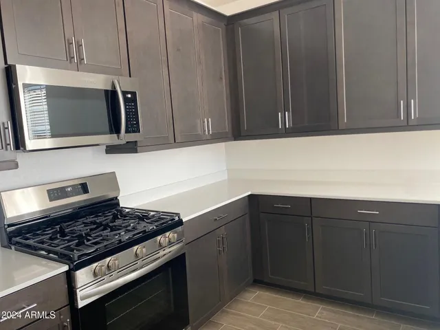 a kitchen with granite countertop a stove microwave and sink