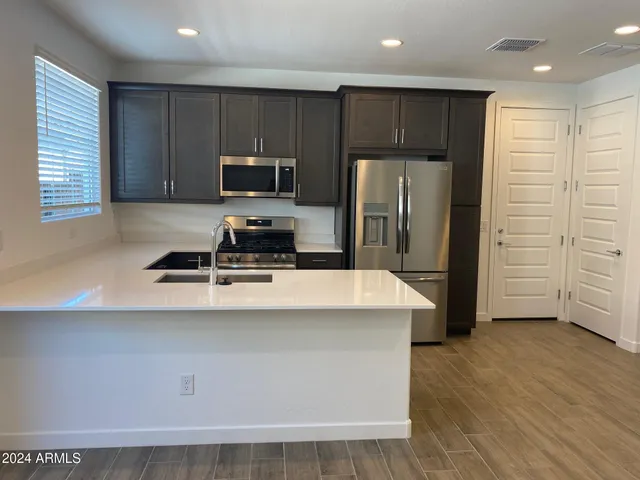 a kitchen with kitchen island a sink stainless steel appliances and cabinets