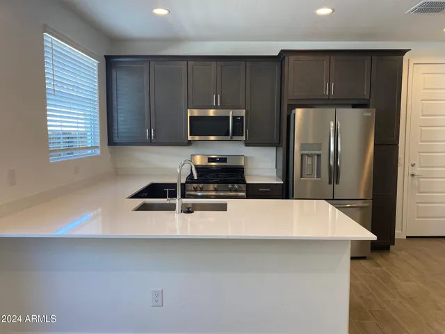 a kitchen with kitchen island a refrigerator sink and microwave