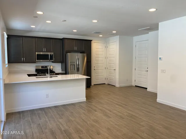 a kitchen with stainless steel appliances a refrigerator and a stove top oven