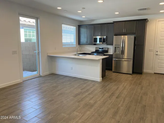 a kitchen with granite countertop a refrigerator and a stove top oven