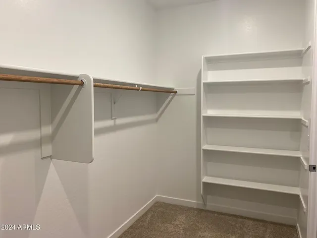 a view of walk in closet with empty racks