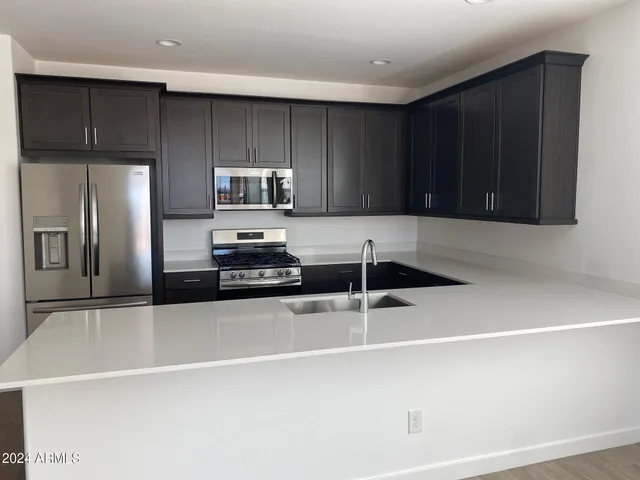 a kitchen with granite countertop a refrigerator and a sink